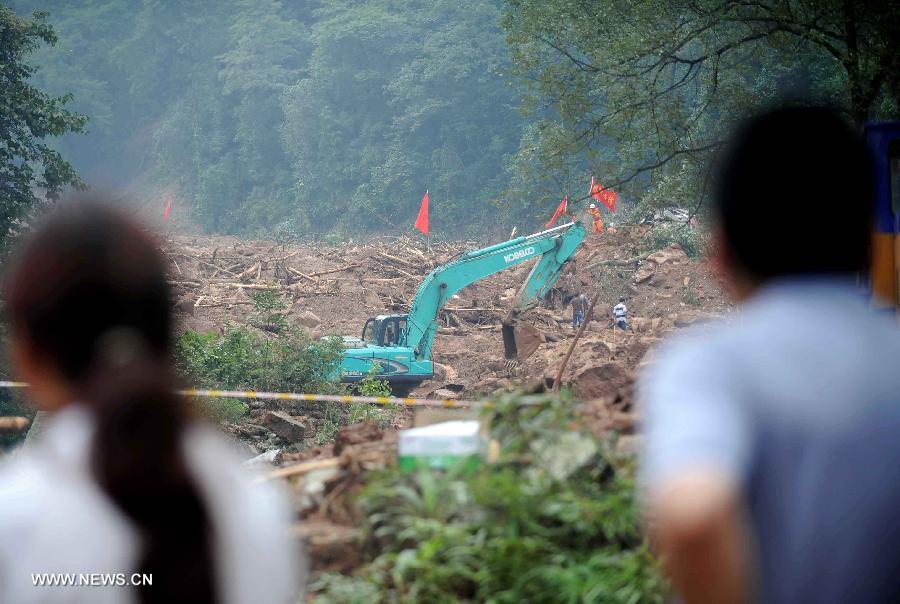 An excavator works at the landslide scene in Sanxi Village of Dujiangyan City, southwest China's Sichuan Province, July 13, 2013. As of 19:00 p.m. (GMT 1100), 43 people were confirmed dead during the landslide that happened in the village of Sanxi on July 10. Some 118 people across the city were missing or can not immediately be reached. Local authorities are continuing to verify the exact number of those missing. Search and rescue work continues. (Xinhua/Xue Yubin)