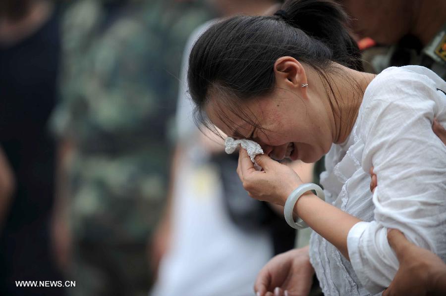 A relative of a victim weeps at the landslide scene in Sanxi Village of Dujiangyan City, southwest China's Sichuan Province, July 13, 2013. As of 19:00 p.m. (GMT 1100), 43 people were confirmed dead during the landslide that happened in the village of Sanxi on July 10. Some 118 people across the city were missing or can not immediately be reached. Local authorities are continuing to verify the exact number of those missing. Search and rescue work continues. (Xinhua/Xue Yubin)