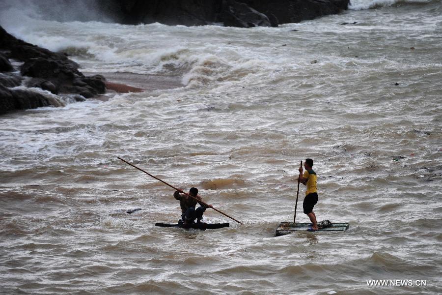 Two local residents try to get ashore on sampans in Lianjiang County, southeast China's Fujian Province, July 13, 2013. Typhoon Soulik landed on the Huangqi Peninsula in Lianjiang Saturday afternoon. (Xinhua/Wei Peiquan) 