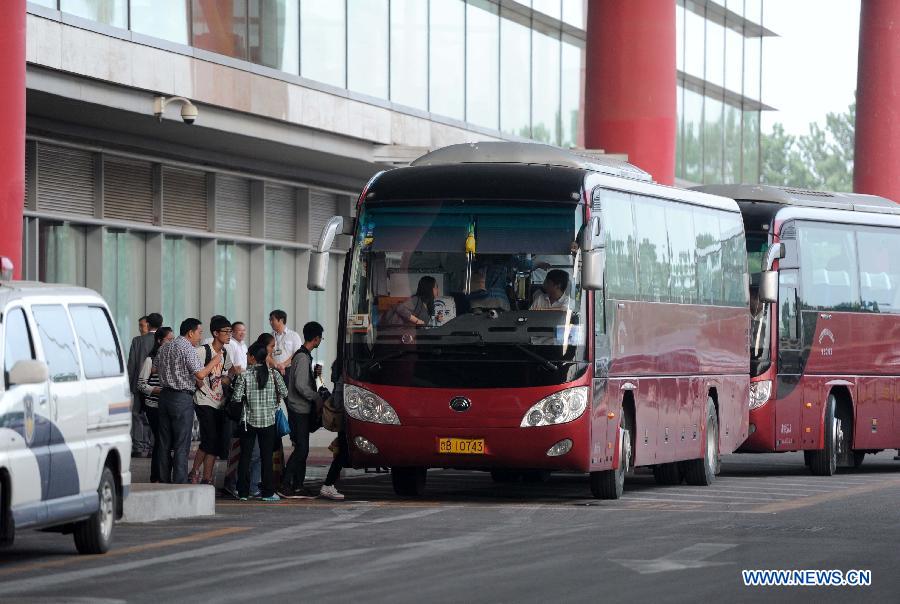 Students and teachers of Jiangshan Middle School board a bus at Capital International Airport in Beijing, capital of China, July 13, 2013. A total of 31 students and teachers who were held up in the U.S. by the crash of Asiana Airlines Flight 214 at San Francisco International Airport returned to China on Saturday. Two Chinese girls were immediately killed during the crash on June 6. Another girl died on June 12 after succumbing to injuries. (Xinhua/Luo Xiaoguang)