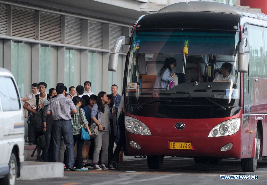 Students and teachers of Jiangshan Middle School board a bus at Capital International Airport in Beijing, capital of China, July 13, 2013. A total of 31 students and teachers who were held up in the U.S. by the crash of Asiana Airlines Flight 214 at San Francisco International Airport returned to China on Saturday. Two Chinese girls were immediately killed during the crash on June 6. Another girl died on June 12 after succumbing to injuries. (Xinhua/Luo Xiaoguang)