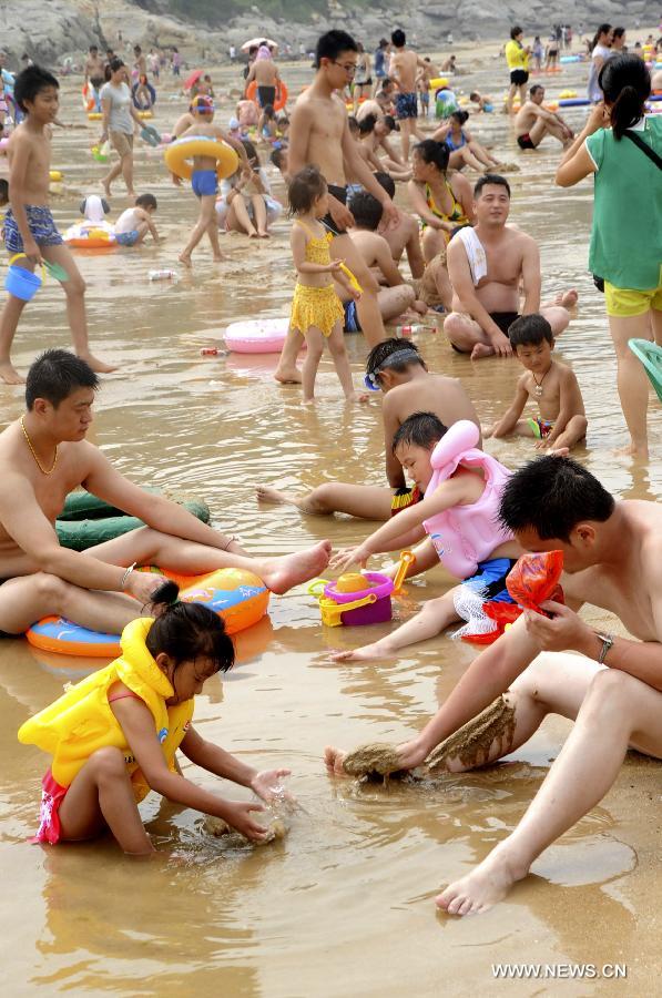 Tourists enjoy coolness at the Dashawan bathing beach in Lianyungang, east China's Jiangsu Province, July 13, 2013. Saturday marks the beginning of the hottest part of summer. Many people came to the seashore to spend a cool weekend. (Xinhua/Wang Chun) 
