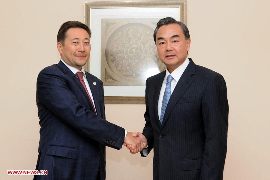 Chinese Foreign Minister Wang Yi (R) meets with Kazakhstan's Deputy Minister of Foreign Affairs Kairat Sarybay as they attend a meeting of the Council of Foreign Ministers of the Shanghai Cooperation Organization (SCO) in Cholpon-Ata, Kyrgyzstan, July 13, 2013.(Xinhua/Guan Jianwu)