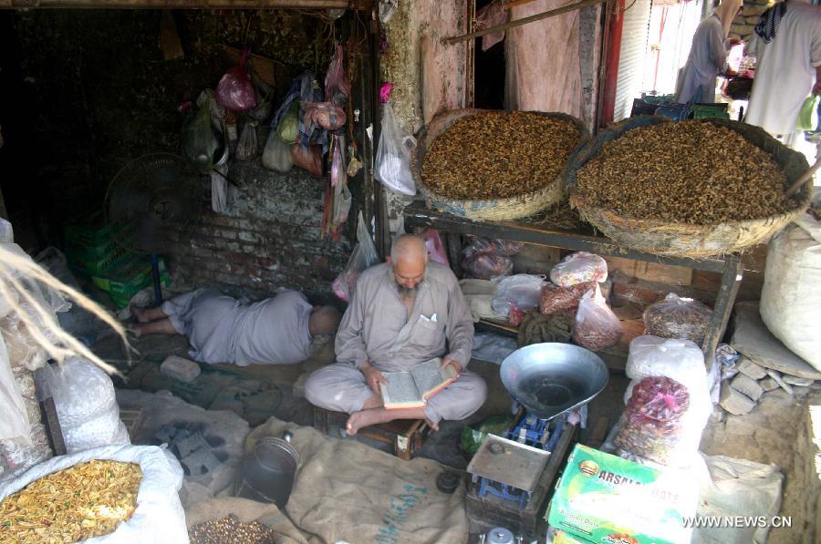 A Pakistani man reads holy Quran at his shop during the holy month of Ramadan in northwest Pakistan's Peshawar, July 13, 2013. Muslims in Pakistan, mostly office workers, go to different mosques after work to attend religious activities during the fasting month of Ramadan. (Xinhua/Ahmad Sidique) 