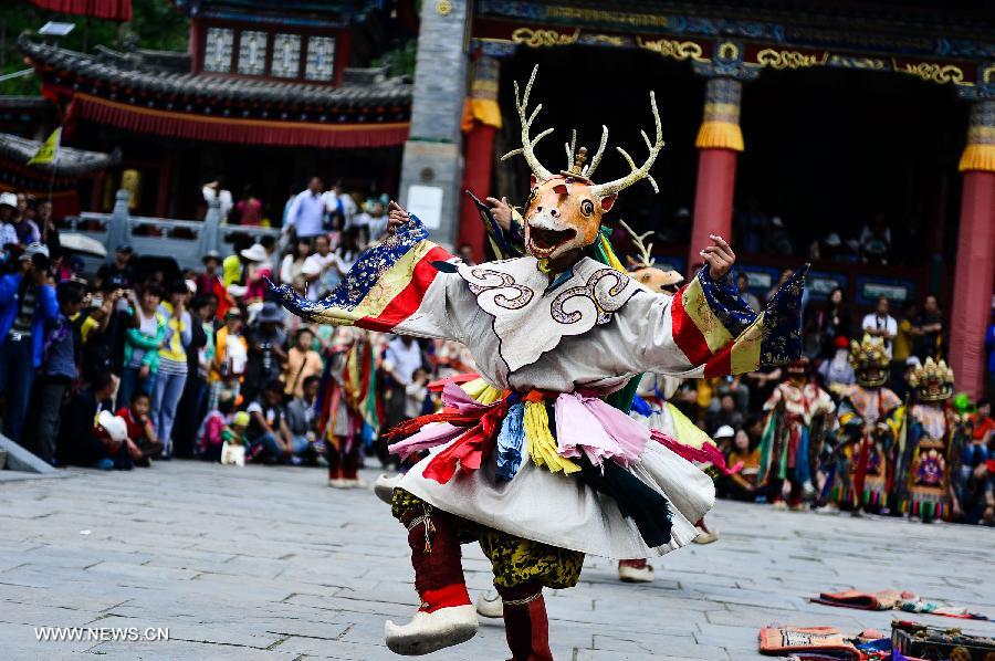 A buddhist wearing a mask attends a ceremony expressing stories of Gods and ghosts in Tibetan Buddhism at the Taer (Gumbum) Monastery in Huangzhong County of Xining, capital of northwest China's Qinghai Province, July 14, 2013. The ceremony, which is called "Tiao Qian" in Chinese, was held on Sunday here at the monastery, the birth place of Tsongkhapa, founder of the Geluk school of Tibetan Buddhism. (Xinhua/Wu Gang)
