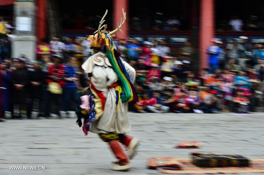 A buddhist wearing a mask attends a ceremony expressing stories of Gods and ghosts in Tibetan Buddhism at the Taer (Gumbum) Monastery in Huangzhong County of Xining, capital of northwest China's Qinghai Province, July 14, 2013. The ceremony, which is called "Tiao Qian" in Chinese, was held on Sunday here at the monastery, the birth place of Tsongkhapa, founder of the Geluk school of Tibetan Buddhism. (Xinhua/Wu Gang)