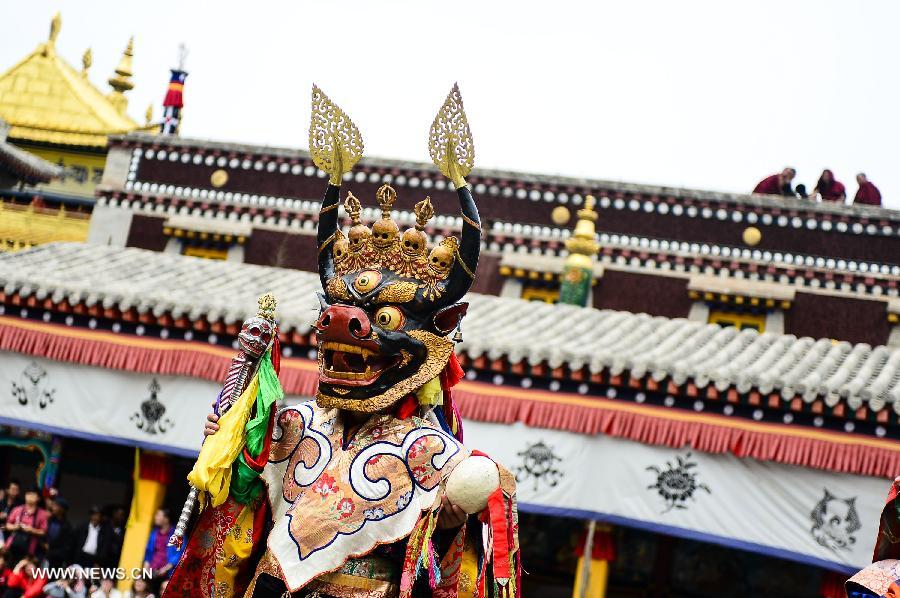 A buddhist wearing a mask attends a ceremony expressing stories of Gods and ghosts in Tibetan Buddhism at the Taer Monastery in Huangzhong County of Xining, capital of northwest China's Qinghai Province, July 14, 2013. The ceremony, which is called "Tiao Qian" in Chinese, was held on Sunday here at the monastery, the birth place of Tsongkhapa, founder of the Geluk school of Tibetan Buddhism. (Xinhua/Wu Gang)