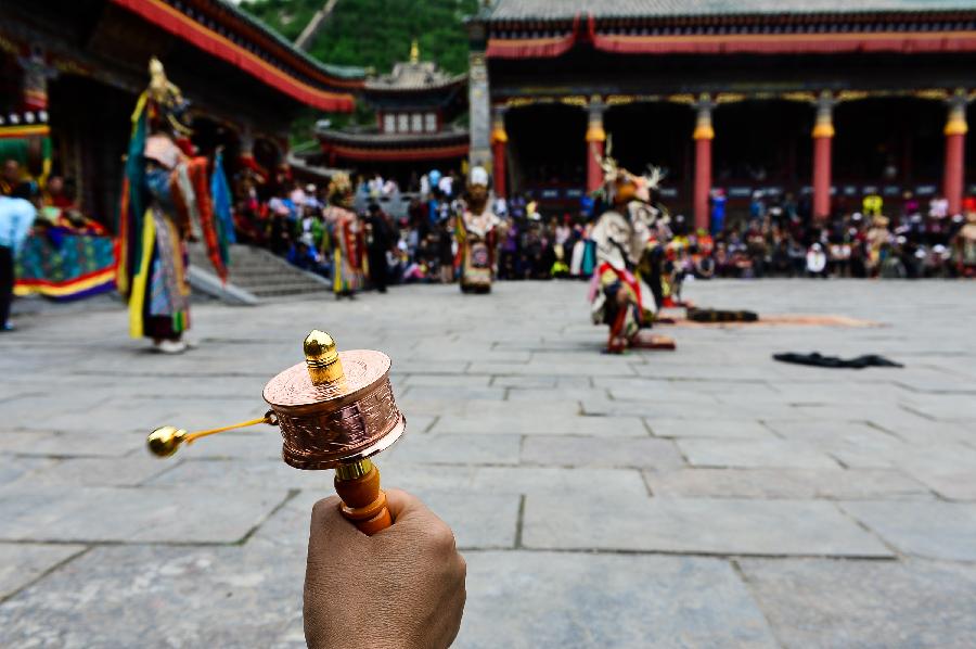 Buddhists wearing masks attend a ceremony expressing stories of Gods and ghosts in Tibetan Buddhism at the Taer (Gumbum) Monastery in Huangzhong County of Xining, capital of northwest China's Qinghai Province, July 14, 2013. The ceremony, which is called "Tiao Qian" in Chinese, was held on Sunday here at the monastery, the birth place of Tsongkhapa, founder of the Geluk school of Tibetan Buddhism. (Xinhua/Wu Gang)