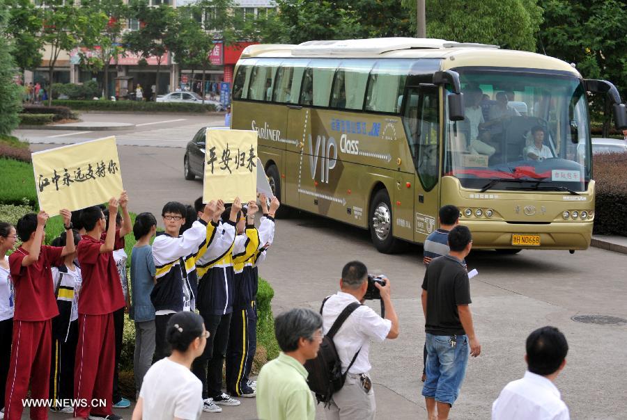 Students and teachers arrive at Jiangshan Middle School by bus in Jiangshan, east China's Zhejiang province, July 14, 2013. A total of 31 students and teachers who were held up in the U.S. by the crashed Asiana Airlines Flight 214 at the San Francisco International Airport returned to Beijing on Saturday and reached home on Sunday. Two Chinese girls were killed on the spot during the crash on July 6. Another girl died on July 12 after succumbing to injuries. (Xinhua/Wang Dingchang)