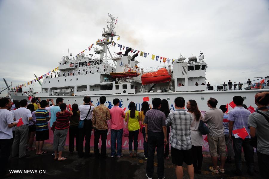 People welcome the arrival of China's patrol and search-and-rescue vessel "Haixun 01" at the Tanjung Priok port in Jakarta, Indonesia, July 14, 2013. China's patrol and search-and-rescue vessel "Haixun 01" arrived at Jakarta on Sunday, commencing its goodwill visit to Indonesia for the next four days. (Xinhua/Zulkarnain)