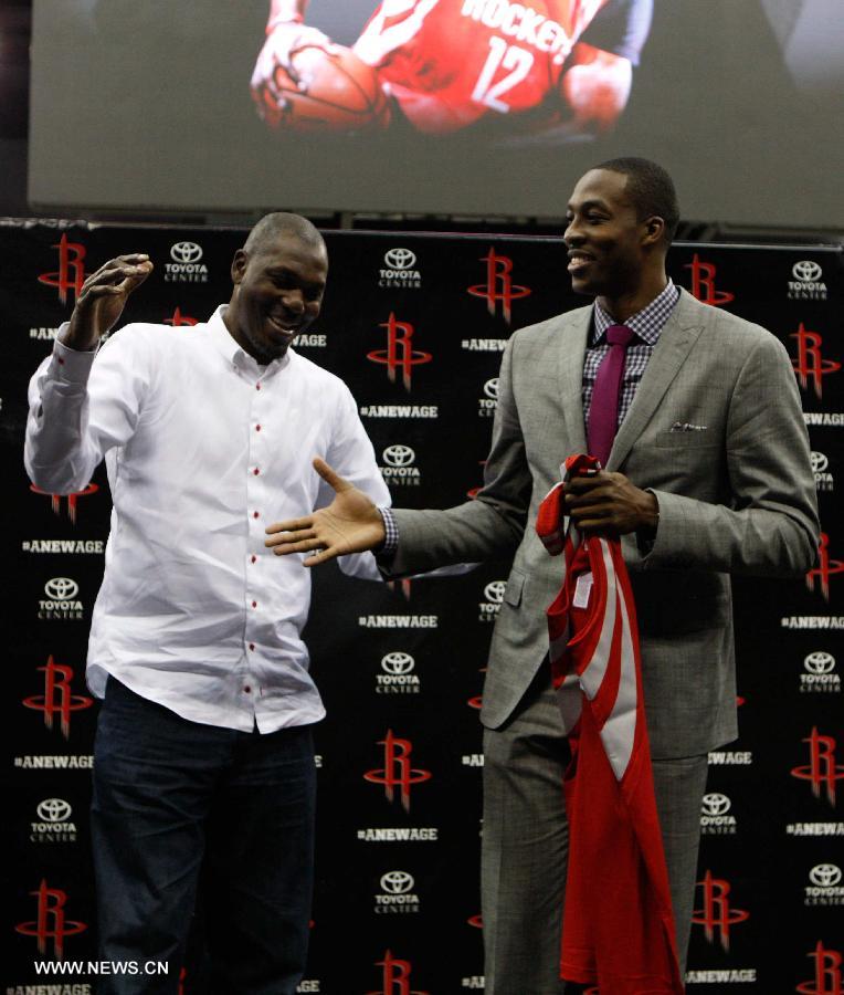 Former Rockets player Hakeem Olajuwon (L) greets Dwight Howard during the news conference and welcoming ceremony for Howard's joining Houston Rockets in Houston, the United States, July 13, 2013. (Xinhua/Song Qiong)