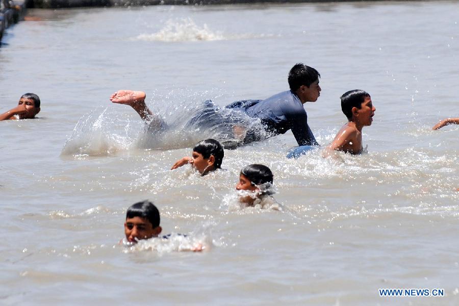 Pakistani children swim in a river canal during heat wave in northwest Pakistan's Peshawar on July 14, 2013. Temperatures reached over 40 degrees Celsius in many parts of the country Sunday. (Xinhua/Umar Qayyum)