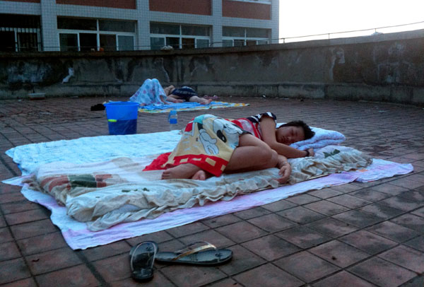 Dormitories turn into steamers when the temperature hits 36 C in Wuhan, Hubei province, and the roof becomes the only place for a good sleep. (Cheng Guo / for China Daily)