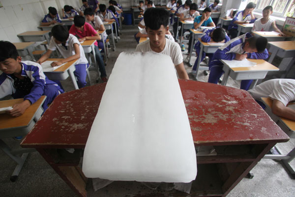 The traditional approach to cooling down is applied today: Large 1-meter-long blocks of ice are placed in the classroom for students during examinations in Jinan, Shandong province. (Zheng Tao / for China Daily)