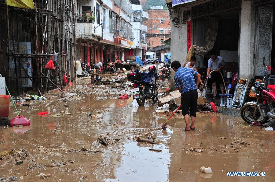 Citizens clean a waterlogged street in Shatian Township in Meizhou City, south China's Guangdong Province, July 14, 2013. Typhoon Soulik-triggered rainstorms battered Meizhou from Saturday night, flooding many roads and farmlands. (Xinhua/Zhong Xiaofeng) 