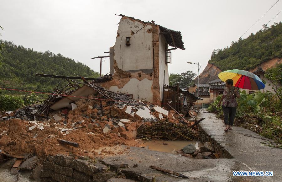 A villager walked past a house destroyed by rainstorms in Liandun Village of Chayang Township in Meizhou City, south China's Guangdong Province, July 14, 2013. Typhoon Soulik-triggered rainstorms battered Meizhou from Saturday night, flooding many roads and farmlands. (Xinhua/Lian Zhicheng) 