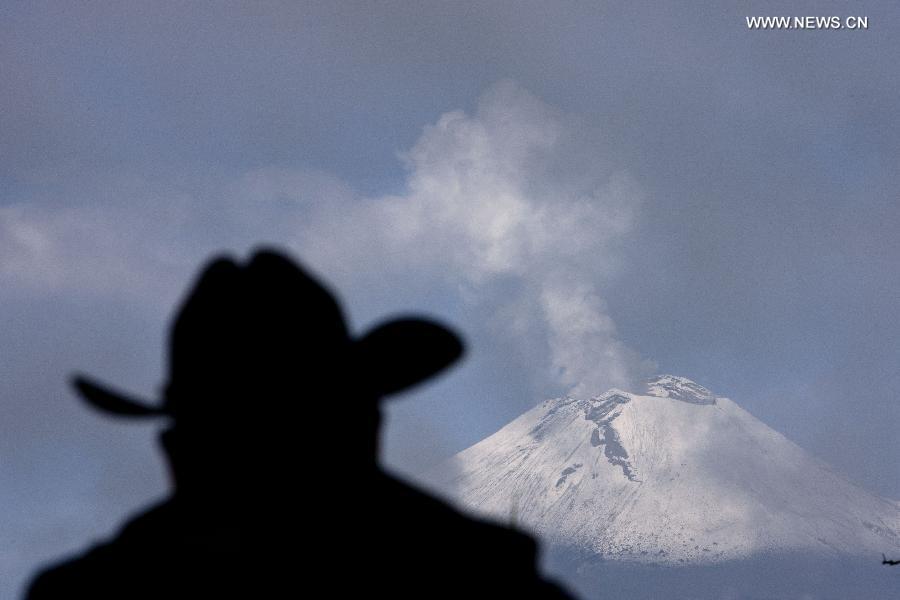 A man looks at the spew of the Popocatepetl volcano in San Andres Calpan of the Calpan municipality, Puebla, central Mexico, on July 14, 2013. (Xinhua/Guillermo Arias) 