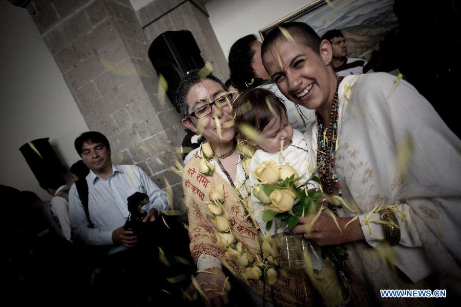A same sex couple react after getting married in a collective gay wedding in Mexico City, capital of Mexico, on July 14, 2013. The collective gay wedding celebrated in Mexico's capital, was presided by Mexico's City Head of Government, Miguel Angel Mancera, according to the local press. (Xinhua/Pedro Mera)