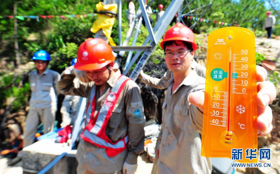 Workers with Transmission and Distribution Engineering Company of Fujian Province make grid maintenance in Xiamen, southeast China's Fujian province, July 4, 2013. The thermometer showed that the temperature was close to 40 degrees Celsius. (Photo/Xinhua)