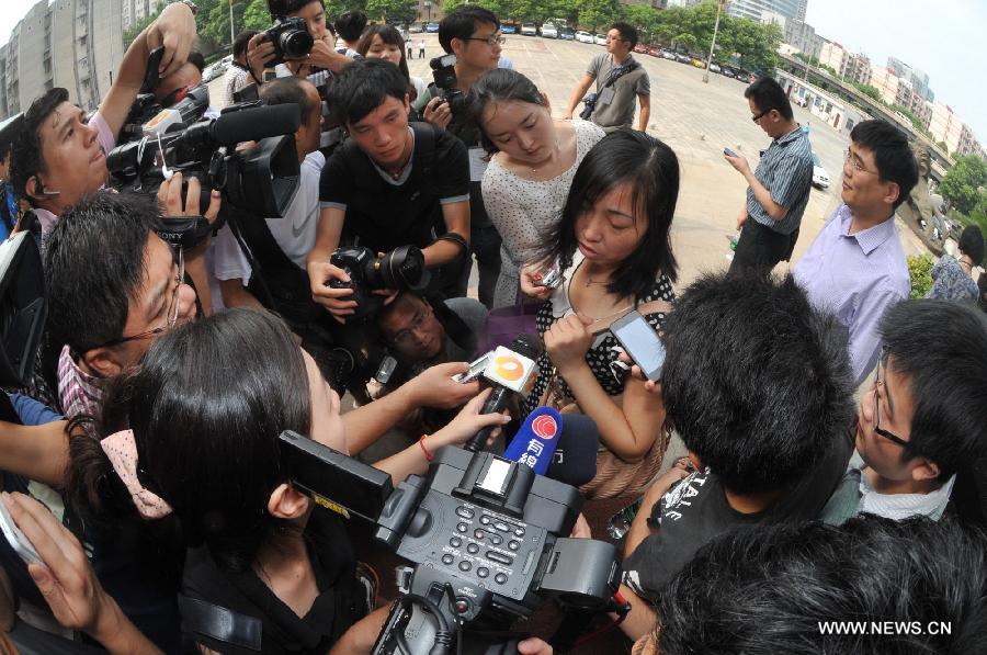 Tang Hui, mother of a young rape victim who sued a local authority for putting her into a labor camp, receives interview after the final ruling outside The Hunan Provincial People's High Court in Changsha, capital of central China's Hunan Province, July 15, 2013. The Hunan Provincial People's High Court on Monday ordered the Yongzhou municipal re-education through labor commission to pay Tang Hui 2,941 yuan (478 U.S. dollars) in compensation for infringing upon her personal freedom and causing mental damages. The 40-year-old mother appealed to the high court in April after the Yongzhou Intermediate People's Court denied her request for an apology and compensation from the re-education through labor commission. Tang was put into the labor camp after she publicly petitioned for harsher punishments for those found guilty of raping her daughter and forcing her into prostitution. (Xinhua/Long Hongtao) 