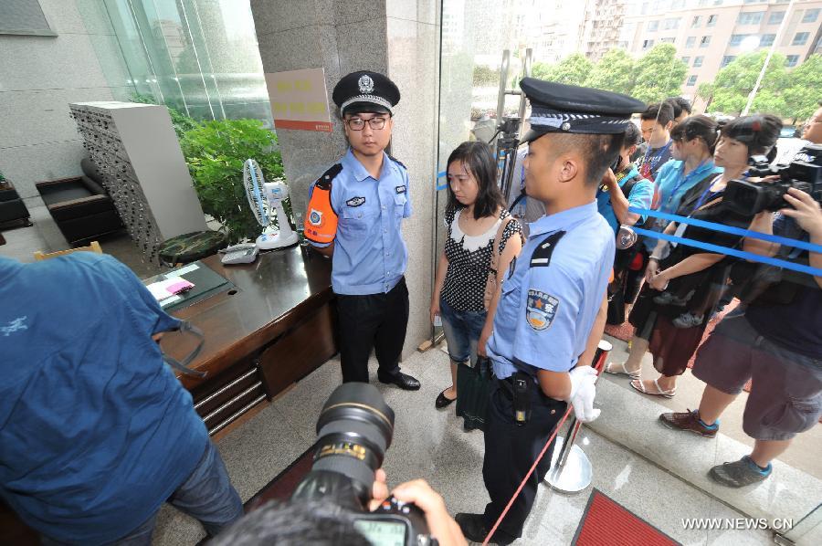 Tang Hui (C) , mother of a young rape victim who sued a local authority for putting her into a labor camp, receives security check before the court hearing in The Hunan Provincial People's High Court in Changsha, capital of central China's Hunan Province, July 15, 2013. The Hunan Provincial People's High Court on Monday ordered the Yongzhou municipal re-education through labor commission to pay Tang Hui 2,941 yuan (478 U.S. dollars) in compensation for infringing upon her personal freedom and causing mental damages. The 40-year-old mother appealed to the high court in April after the Yongzhou Intermediate People's Court denied her request for an apology and compensation from the re-education through labor commission. Tang was put into the labor camp after she publicly petitioned for harsher punishments for those found guilty of raping her daughter and forcing her into prostitution. (Xinhua/Long Hongtao)