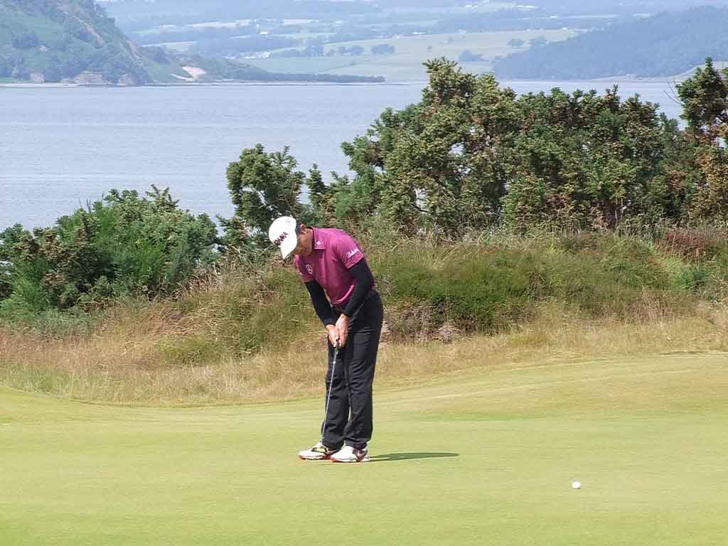 Beautiful BackdropLiang Wenchong sets his putt rolling against a beautiful Scottish backdrop. (Photo/ David Ferguson)