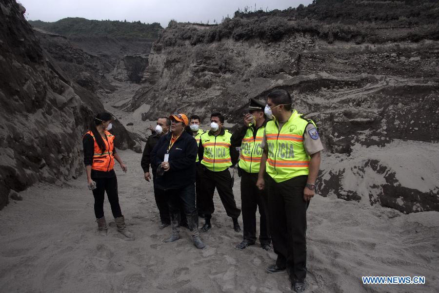 National Police members observe a path covered with ashes near the Tungurahua volcano, in the Tungurahua province, Ecuador, on July 14, 2013. The Ecuador's Risk Management Secretariat, declared an orange alert in some locations near the volcano where several families have been evacuated to the shelters prepared for the emergency, according to local press. (Xinhua/Str)