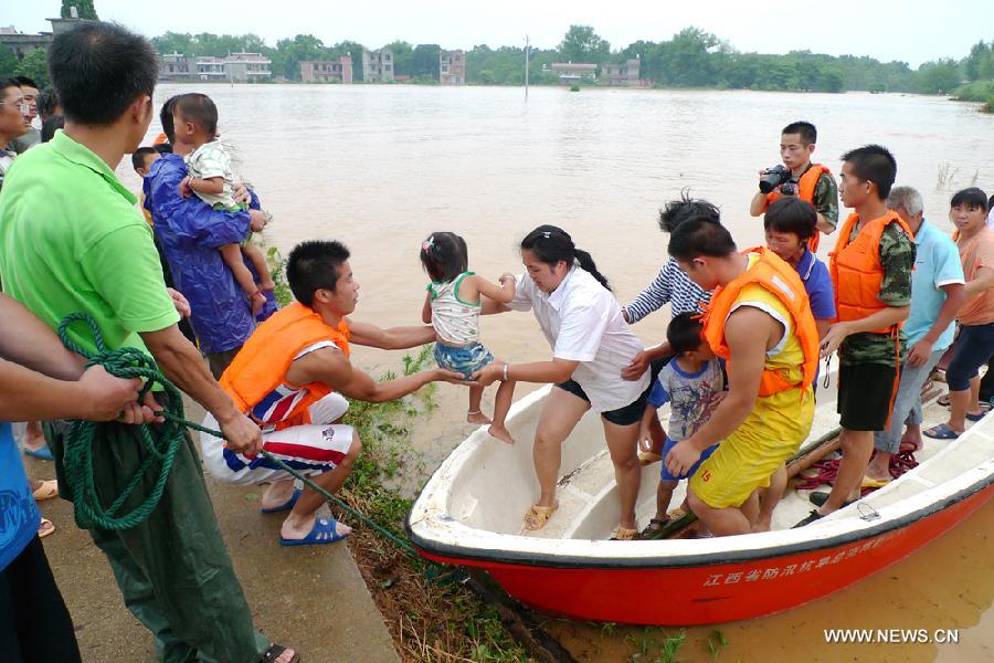 Rescuers evacuate stranded villagers in Taihe County, east China's Jiangxi Province, July 14, 2013. Affected by Typhoon Soulik, Taihe County has been battered by torrential rainfalls since July 13, forcing the evacuation of some 2,400 locals. (Xinhua/Liang Shengbin)