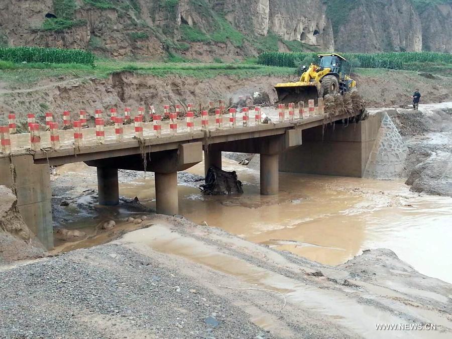 Photo taken on July 15, 2013 shows a collapsed bridge destroyed by a rain-triggered floods in Fanjiachuan Village of Qingyang City, northwest China's Gansu Province. Two people were killed, one was injured and six others were reported missing in the rain-triggered floods. Rescue work is underway. (Xinhua/Li Pengbo)