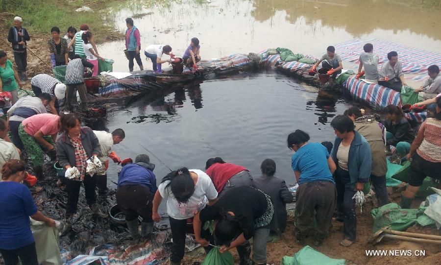 Villagers help clean oil stains in the Zichang County, northwest China's Shaanxi Province, July 15, 2013. The oil pipe from Ansai County to Yongping Town was damaged by mudslide following days of rainstorms. Rescue efforts for repairing the broken pipe are underway. (Xinhua) 