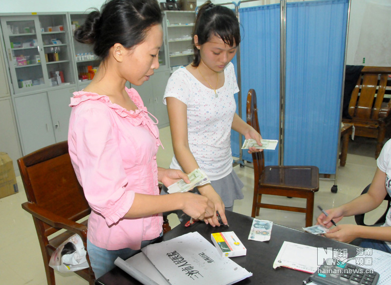 A villager comes to the clinic to buy medicine. A new and bigger hospital is being built to replace two clinical rooms, shown on the left, that serve Yongxing island of Sansha, Hainan province, on July 8, 2013.(Xinhua/Yu Tao)