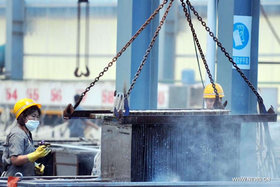 Photo taken on June 29, 2013 shows workers washing equipment in a mineral company in Xiushan County, southwest China's Chongqing. China's gross domestic product (GDP) totaled 24.8 trillion yuan (4 trillion U.S. dollars) in the first half of 2013, with the growth at 7.6 percent, which is in line with market expectations and was above the government's full-year target of 7.5 percent, data from China's National Bureau of Statistics (NBS) showed on July 15, 2013. (Xinhua/Chen Yehua)