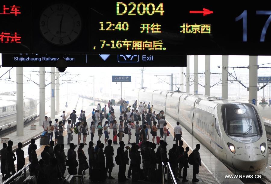 Passengers wait to board the train at Shijiazhuang Railway Station, north China's Hebei Province, July 1, 2013. China's gross domestic product (GDP) totaled 24.8 trillion yuan (4 trillion U.S. dollars) in the first half of 2013, with the growth at 7.6 percent, which is in line with market expectations and was above the government's full-year target of 7.5 percent, data from China's National Bureau of Statistics (NBS) showed on July 15, 2013.(Xinhua/Wang Xiao)