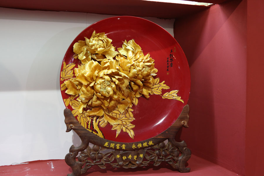 Porcelain artwork featuring the pattern of peony flowers is shown at the 2013 China International Consumer Products Exhibition. (CRIENGLISH.com/Wang Wei)