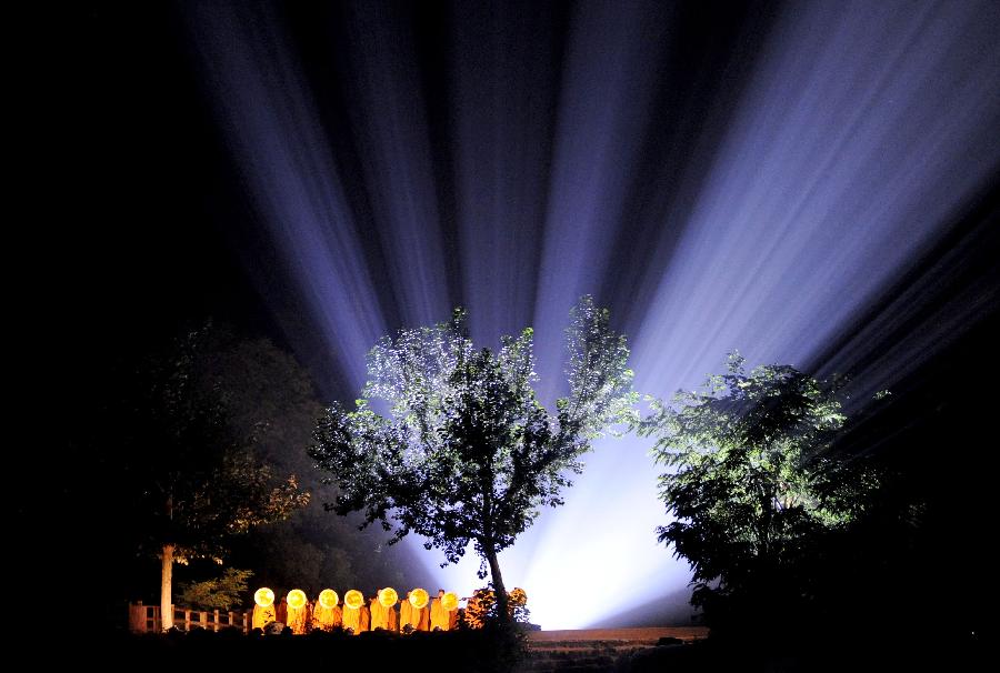 Actors perform in the music ritual in Zhengzhou, capital of central China's Henan Province, July 14, 2013. The real scene show "Shaolin Zen Music Ritual" has run for more than 1,600 performances since its premiere in May, 2007. The music ritual was shown on the natural stage of the Songshan Mountain to present a rhythm combined with natural sounds and the "Zen Music". (Xinhua/Zhu Xiang)