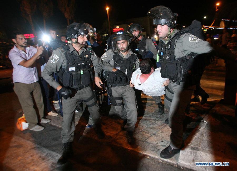 Israeli security forces arrest a Palestinian protestor outside the Damascus Gate in Jerusalem on July 15, 2013, during a demonstration against the Israeli government's plan to relocate Bedouins in the Negev Desert. There are around 260,000 Bedouin in Israel, who mostly live in and around the Negev in the arid south. (Xinhua/Muammar Awad)