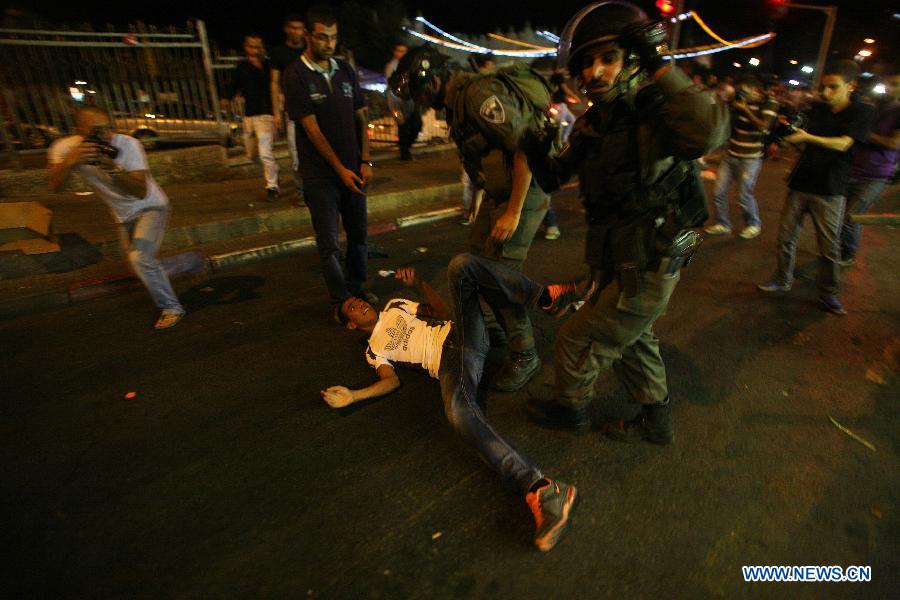 Israeli security forces arrest a Palestinian protestor outside the Damascus Gate in Jerusalem on July 15, 2013, during a demonstration against the Israeli government's plan to relocate Bedouins in the Negev Desert. There are around 260,000 Bedouin in Israel, who mostly live in and around the Negev in the arid south. (Xinhua/Muammar Awad)