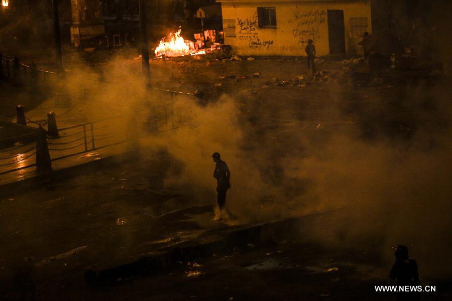 A supporter of ousted Egyptian President Mohamed Morsi stands in the middle of teargas in Ramsis square, downtown Cairo, Egypt on July 15, 2013. Clashes erupted between pro-Morsi protesters and riot police when police force fired teargas and rubber bullets at a pro-Morsi march heading to Giza square, at least 100 protesters are injured, according the official Egyptian Ambulance Organization. (Xinhua/Amru Salahuddien)