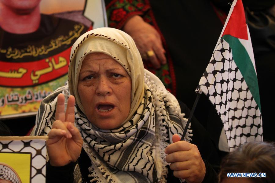 A Palestinian woman takes part in a protest to demand release of Palestinian prisoners held by Israel outside Red Cross office in Gaza City, on July 15, 2013. (Xinhua/Yasser Qudih)