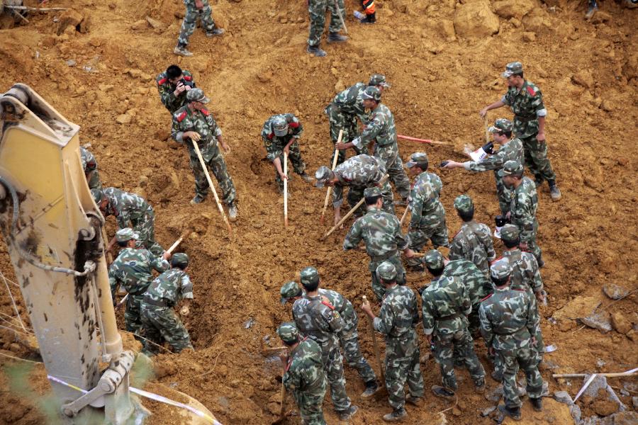 Rescuers work at a landslide site in Qixingguan District of Bijie City, southwest China's Guizhou Province, July 15, 2013. The landslide happened around 3:00 p.m., burying six people in total. Among the four people who were found, three were killed and one injured. (Xinhua) 