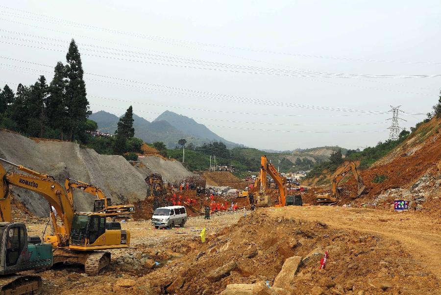 Excavators are seen at a landslide site in Qixingguan District of Bijie City, southwest China's Guizhou Province, July 15, 2013. The landslide happened around 3:00 p.m., burying six people in total. Among the four people who were found, three were killed and one injured. (Xinhua)
