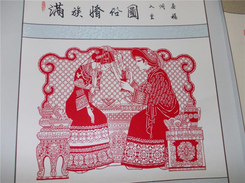 A paper-cut design depicting Manchu wedding customs displayed at the 4th Chinese paper-cut art festival in Wei county, Hebei province. The festival was held July 8-10 and featured works from over 360 folk artists around China. (China Daily/Tang Zhe)