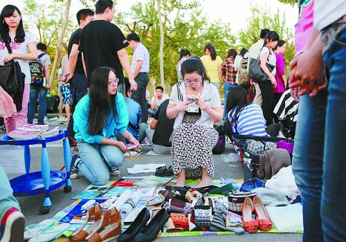 A graduate counts how much she has earned for the day at a flea market.（Photo/China Youth Daily）
