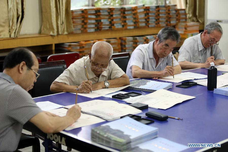 Retired lecturers write admission notices with writing brush, as a special gift for the newly-recruited students of Shaanxi Normal University, in Xi'an City, northwest China's Shaanxi Province, July 15, 2013. Unlike the printed university adimission notice issued by most of universities in China, Shaanxi Normal University organized more than 20 retired lecturers to write the notice by hand this year. China's annual university recruitment is underway. (Xinhua/Hou Zhi)