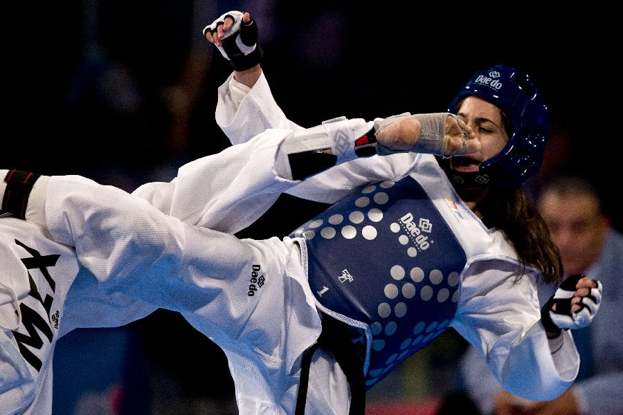 Kyriaki Kouttouki from Cyprus, recives a kick during her combat against Itzel Manjarrez from Mexico in the 46 kg women's category of the Taekwondo World Championship of the World Taekwondo Federation (WTF), in the Expositions and Coventions Center of Puebla, in Puebla, Mexico, on July 15, 2013 (Xinhua/Guillermo Arias)