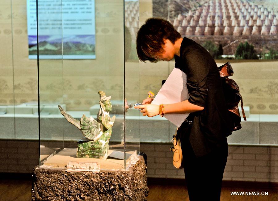 A visitor takes a photo of an exhibit at a public exhibition presenting elaborate antiques of the Xixia Kingdom at the Heilongjiang Provincial Museum in Harbin, capital of northeast China's Heilongjiang Province, July 16, 2013. Xixia (1032-1227), or Western Xia, was a feudal kingdom established by the Tangut ethnic group at the eastern end of the ancient Silk Road. Its territory largely overlapped today's Ningxia Hui Autonomous Region in northwest China. (Xinhua/Wang Song) 