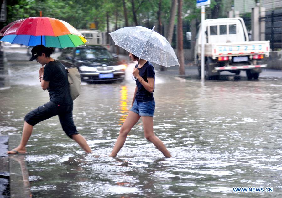 People walk on a flooded road in Shenyang, capital of northeast China's Liaoning Province, July 16, 2013. Shenyang was hit by a rainstorm on Tuesday. (Xinhua/Zhang Wenkui) 