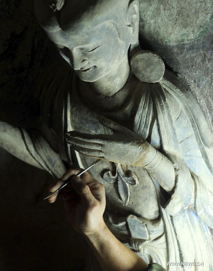 A worker repairs a sculpture at the Maiji Mountain Grottoes in Tianshui, northwest China's Gansu Province, July 15, 2013. After protection and preparation, the Maiji Mountain Grottoes, the fourth largest grottoes in China and known as the "Oriental Sculpture Museum", has been ready for the application for status on the World Heritage List in 2014, as a part of the application program of the 2,000-year-old Silk Road which China works with Kazakstan and Kyrgyzstan and was officially submitted to the United Nations Educational, Scientific and Cultural Organization (UNESCO) in January of 2013. China has altogether 22 historical sites in this application program, including seven in Xinjiang, five in Gansu, six in Shaanxi and four in Henan. (Xinhua/Nie Jianjiang) 