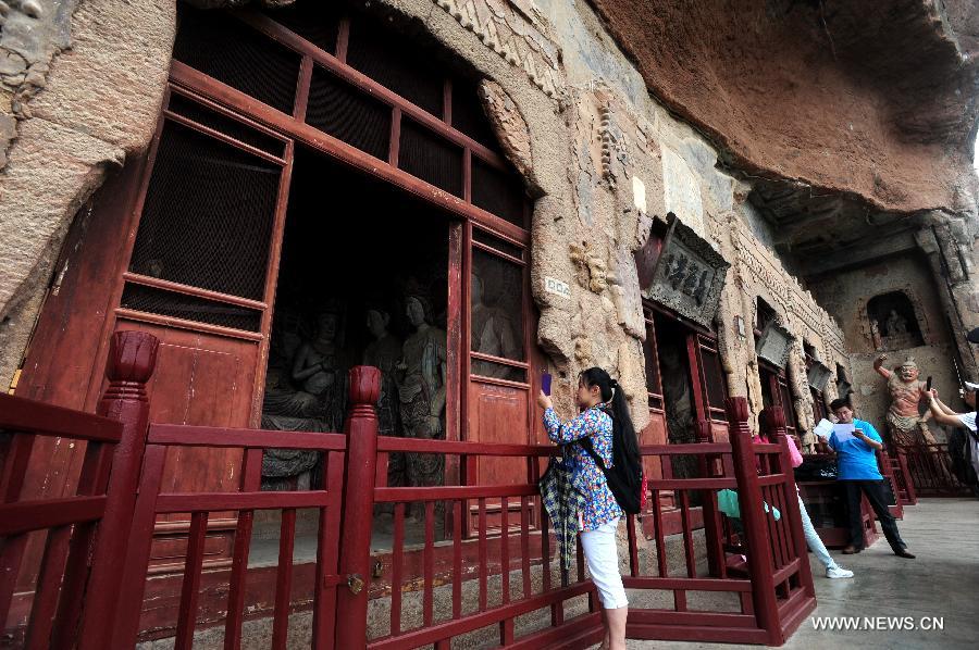 People visit the Maiji Mountain Grottoes in Tianshui, northwest China's Gansu Province, July 15, 2013. After protection and preparation, the Maiji Mountain Grottoes, the fourth largest grottoes in China and known as the "Oriental Sculpture Museum", has been ready for the application for status on the World Heritage List in 2014, as a part of the application program of the 2,000-year-old Silk Road which China works with Kazakstan and Kyrgyzstan and was officially submitted to the United Nations Educational, Scientific and Cultural Organization (UNESCO) in January of 2013. China has altogether 22 historical sites in this application program, including seven in Xinjiang, five in Gansu, six in Shaanxi and four in Henan. (Xinhua/Nie Jianjiang) 