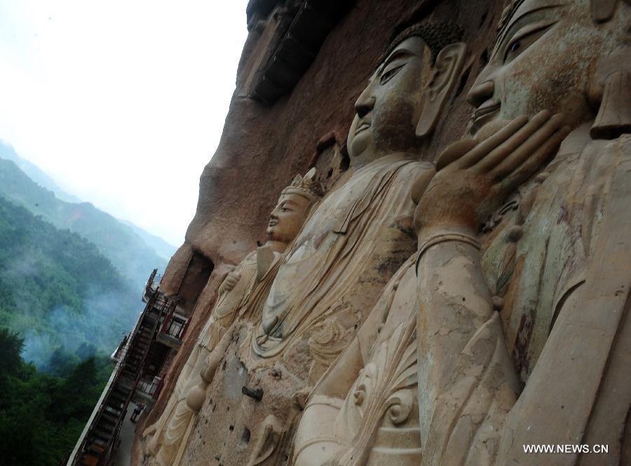 Photo taken on July 15, 2013 shows sculptures on the cliff of the Maiji Mountain Grottoes in Tianshui, northwest China's Gansu Province. After protection and preparation, the Maiji Mountain Grottoes, the fourth largest grottoes in China and known as the "Oriental Sculpture Museum", has been ready for the application for status on the World Heritage List in 2014, as a part of the application program of the 2,000-year-old Silk Road which China works with Kazakstan and Kyrgyzstan and was officially submitted to the United Nations Educational, Scientific and Cultural Organization (UNESCO) in January of 2013. China has altogether 22 historical sites in this application program, including seven in Xinjiang, five in Gansu, six in Shaanxi and four in Henan. (Xinhua/Nie Jianjiang) 